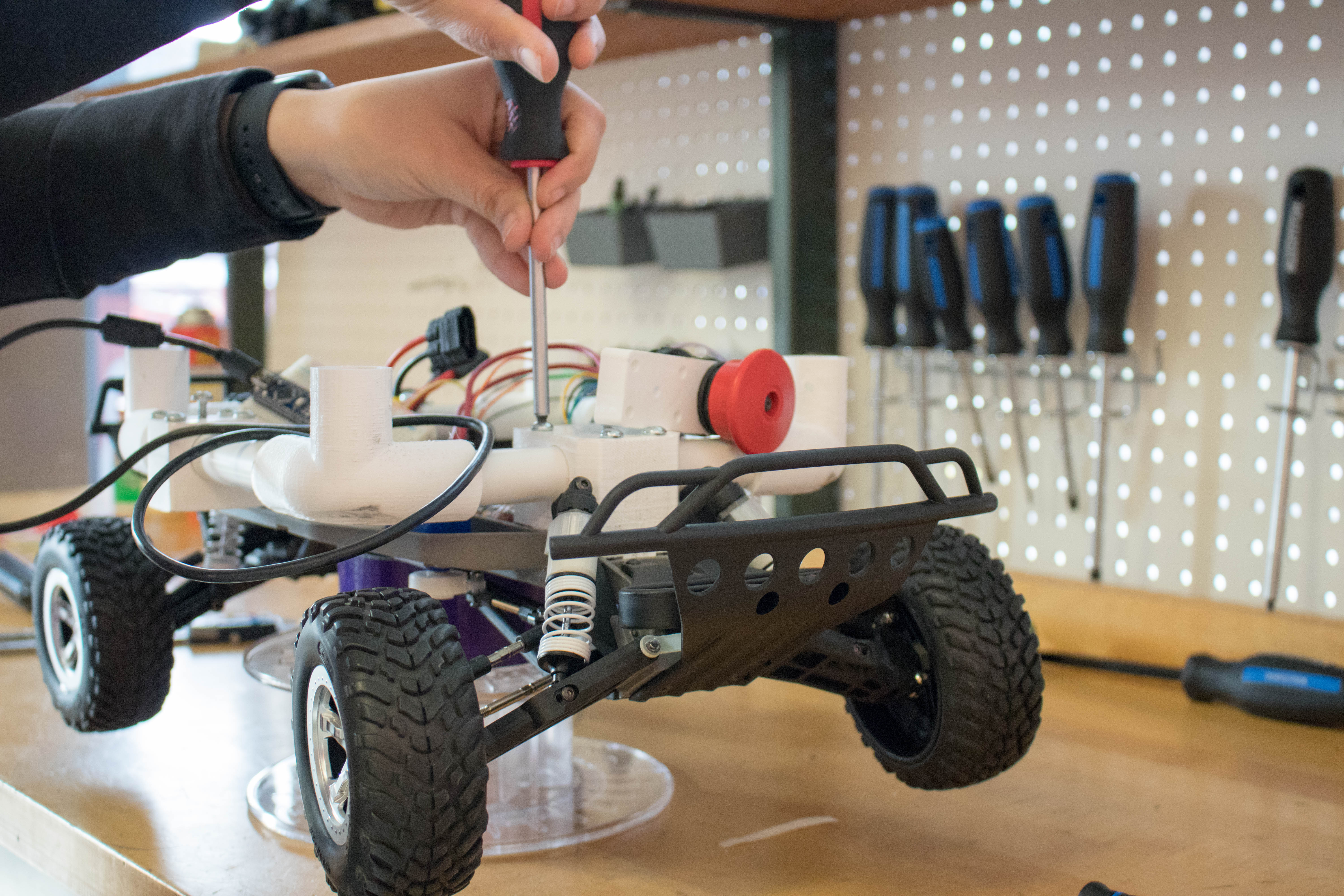 Close up of a student working on a miniature robot car